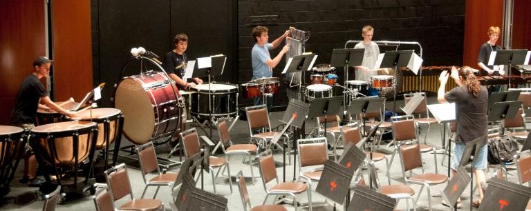 Percussion players practicing with conductor